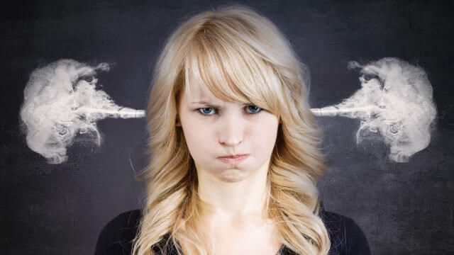 Angry young woman, blowing steam coming out of ears
