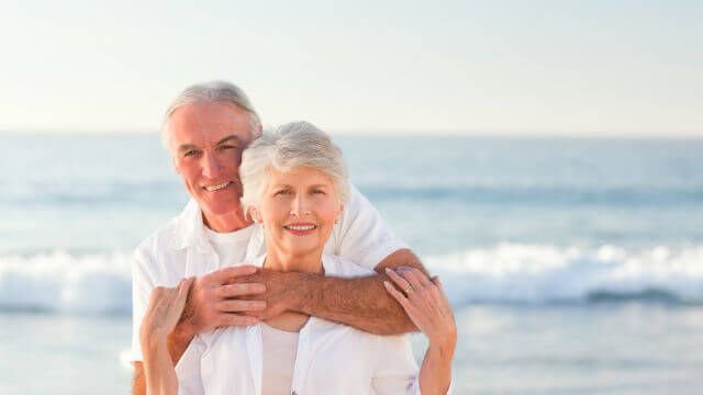 Man hugging his wife on the beach