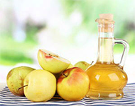 Apple cider vinegar in glass bottle and ripe fresh apples,