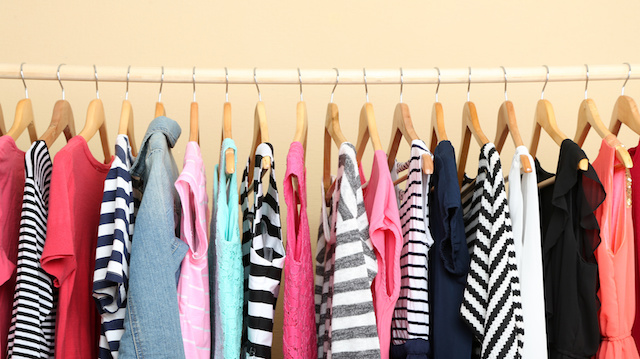 Colorful clothes on hangers in room