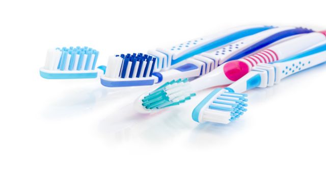 Toothbrushes on a white matte surface closeup