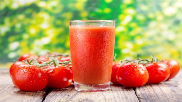glass of tomato juice on wooden table