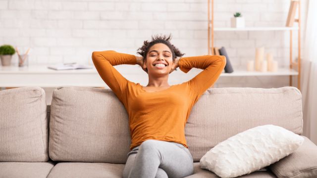 Happy Black Woman Relaxing Sitting On Sofa At Home