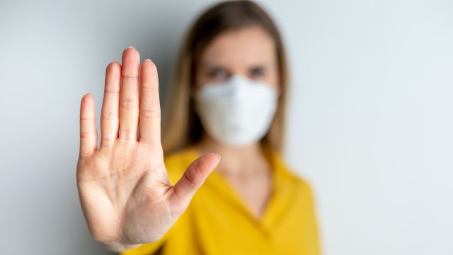 Virus mask woman wearing face protection in prevention for coronavirus showing gesture Stop Infection